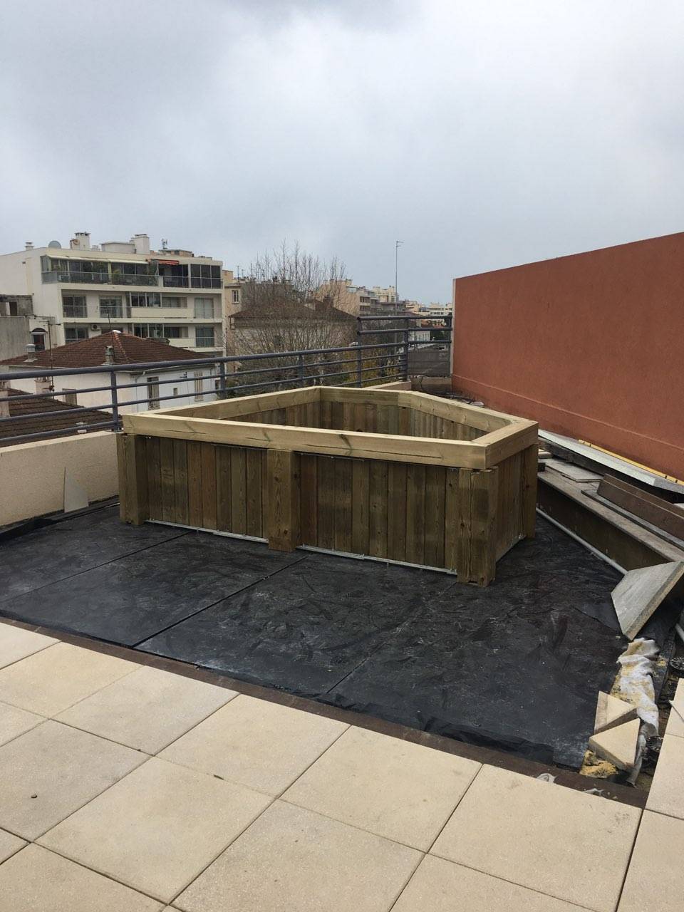 Installation d'une mini-piscine en bois sur le toit-terrasse d'un immeuble à Antibes dans le département des Alpes-Maritimes et la région PACA