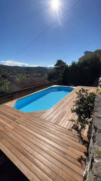 Jolie piscine en bois entourée d'une terrasse sous le soleil des bouches du rhone