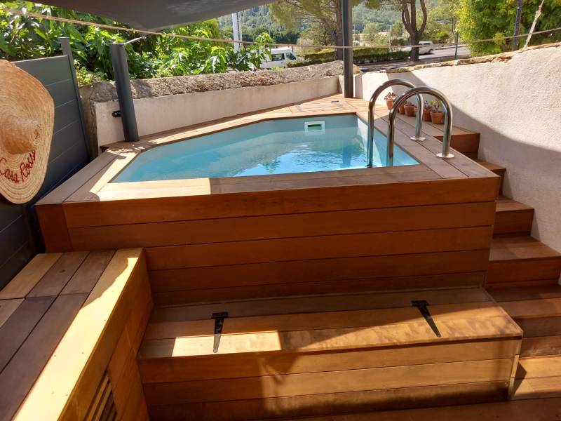 Fabrication d'une terrasse en bois exotique avec des marches et un coffre autour d'une piscine en bois à Signes