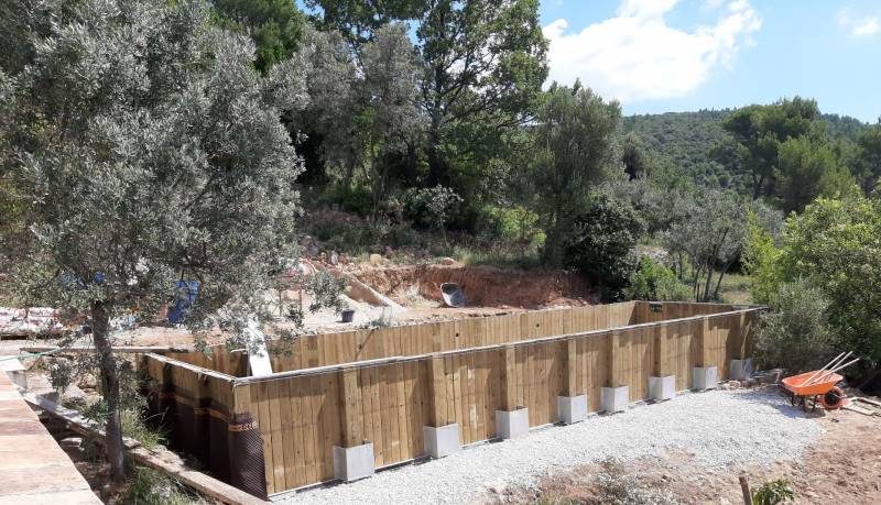 DRAGUIGNAN 83, fabrication d'une piscine en bois hors-sol de forme couloir de nage, d'une dimension de 14x4 m, installée sur un terrain en terrasses